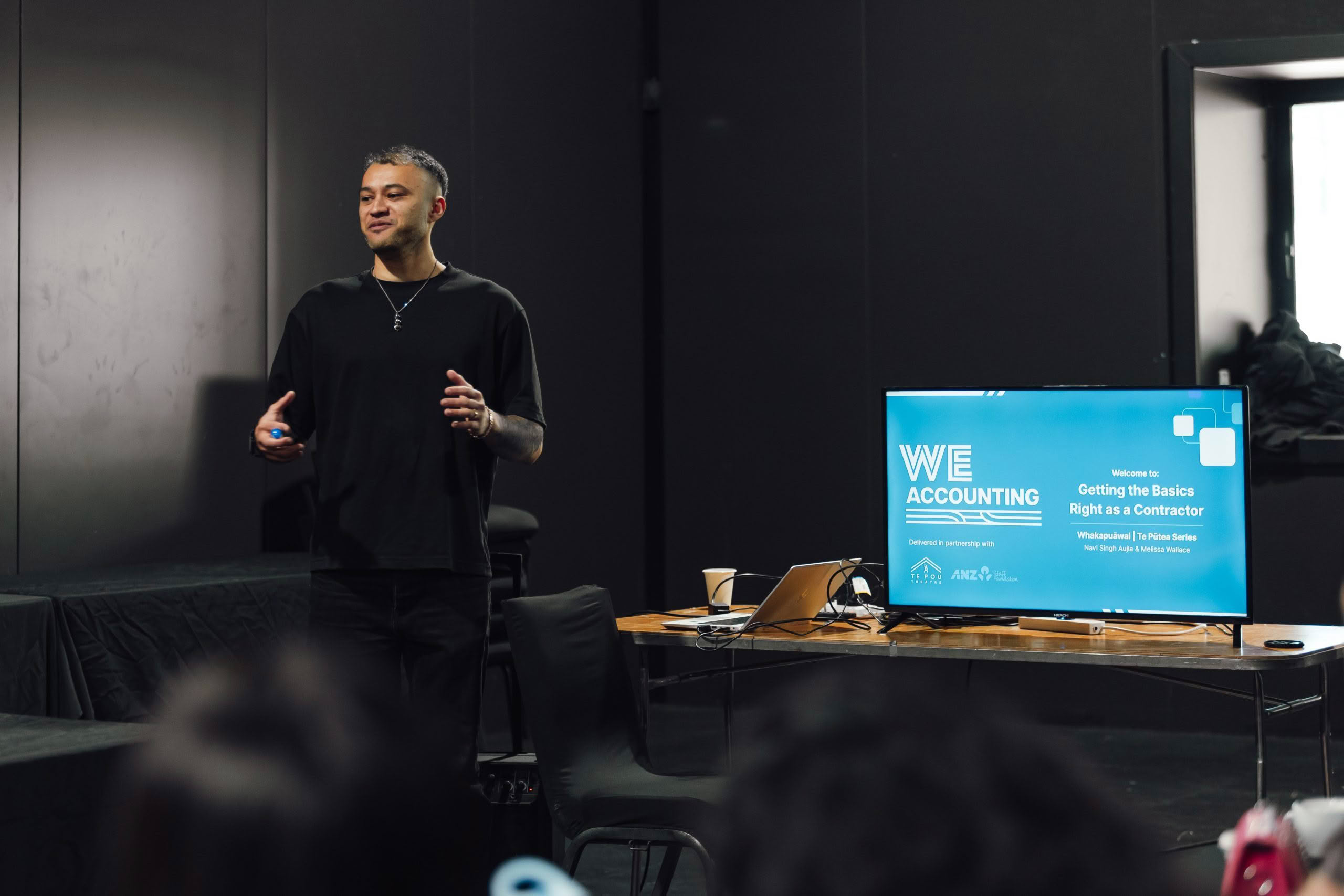 "Financial literacy workshop presenter speaking to audience of small business owners"